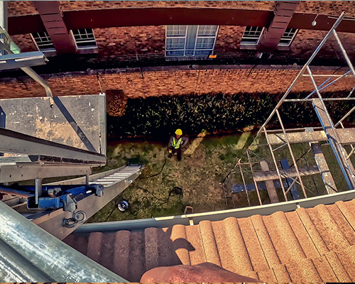 looking down from a roof to see how people, equipment and solar panels get on the roof.