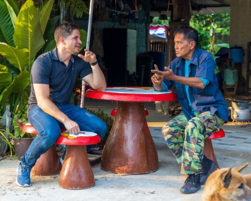 Josh Terndrup, the leader of Antioch Ministries International in Thailand, speaks with a Thai man in a village in Thailand. The village recently received land to build a church.