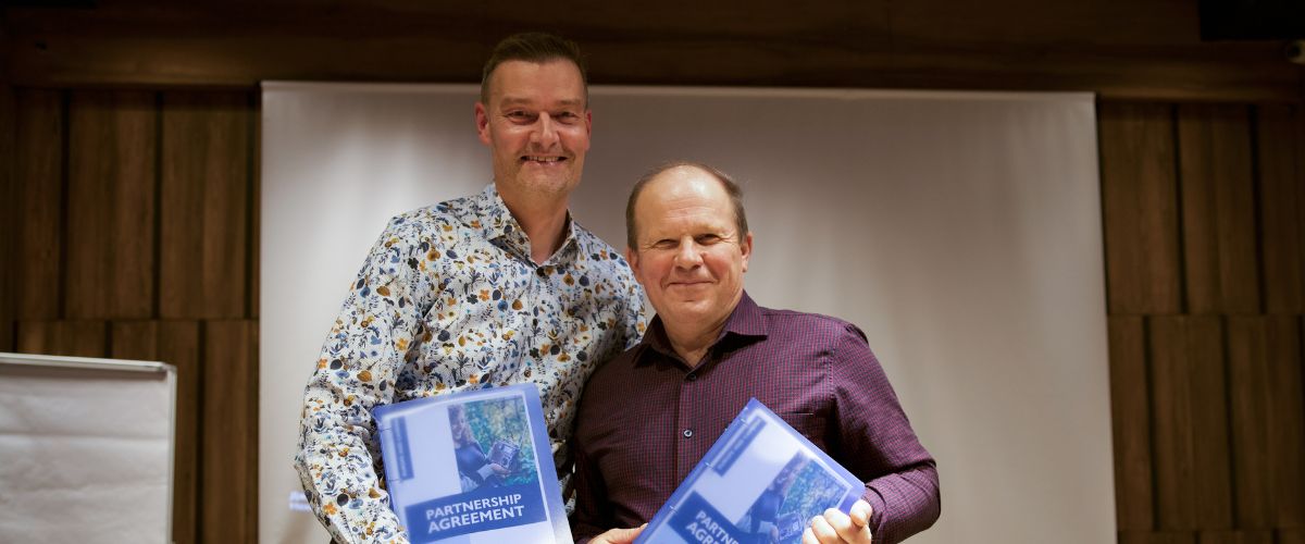 TWR’s International Director for Europe Dirk Mueller (left) and TWR Ukraine Director Alexander Chmut (right) display their partnership agreements during a respite visit from TWR family members to Ukraine. 