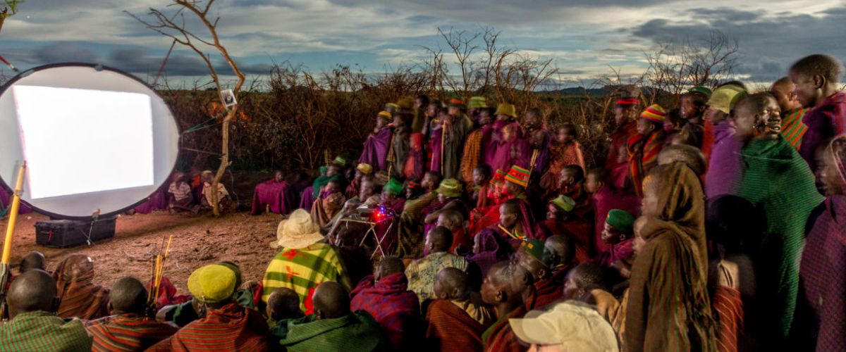 Dozens of Karamajong warrior shepherds gather around a screen to see the JESUS film in their native tongue in northeastern Uganda.